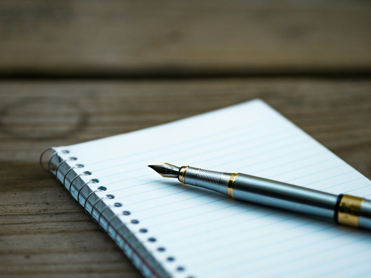 Carnet à spirale ligné avec un stylo-plume posé à côté